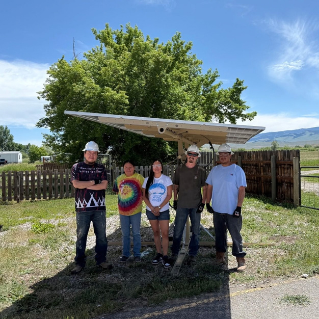 Wind River community members in hard hats with solar tracking equipment